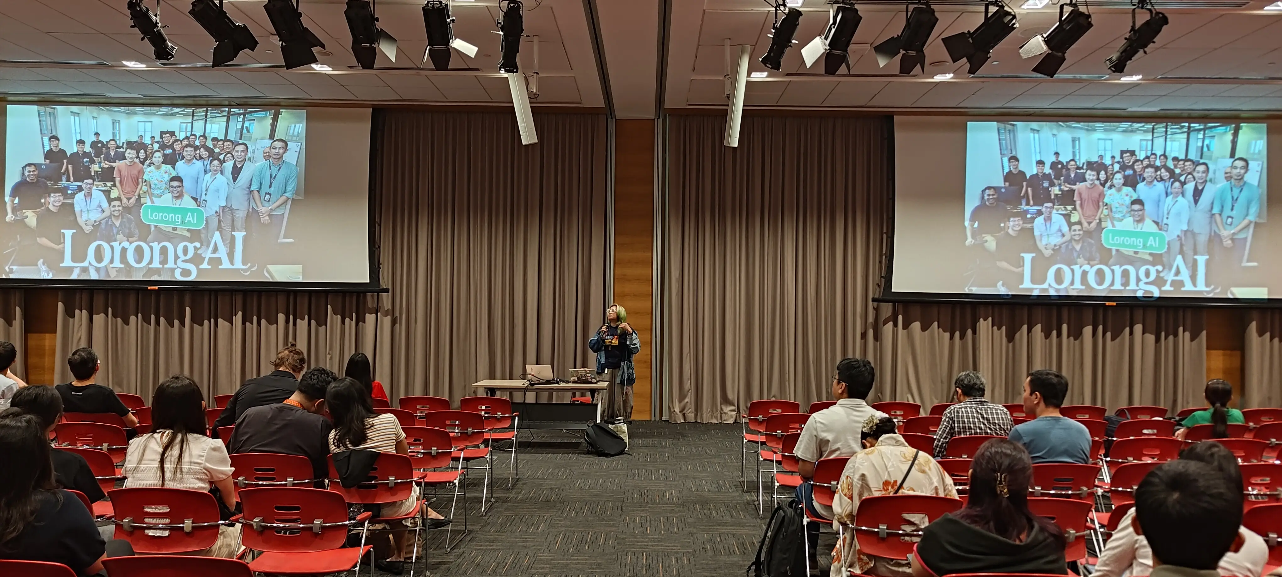 Georgi Ker presenting her keynote for PyConSG 2026 with two large screens displaying "Lorong AI"