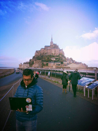 The writer checking email in front of Mont Saint Michel